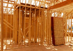 A house under construction is framed with beams.